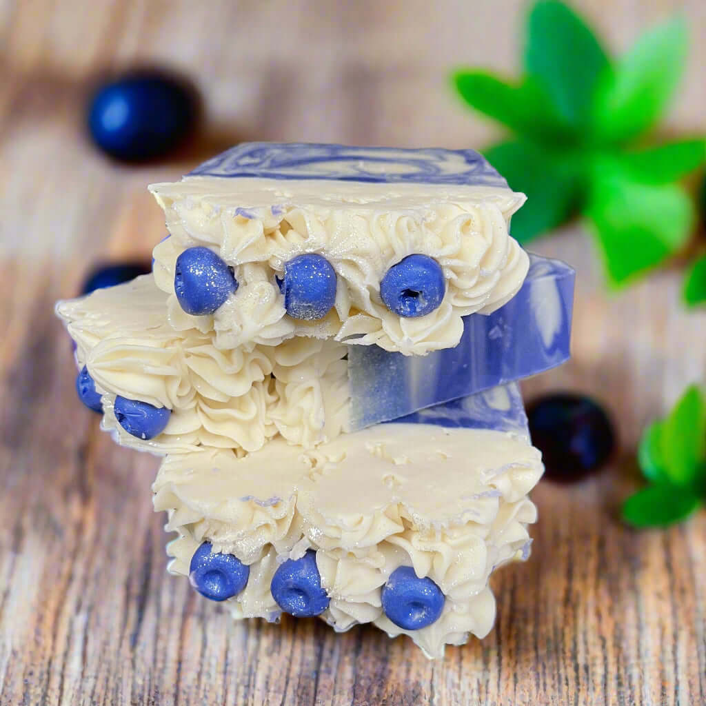 Huckleberry Harvest Soap bars with natural blueberry accents on a rustic wooden surface.