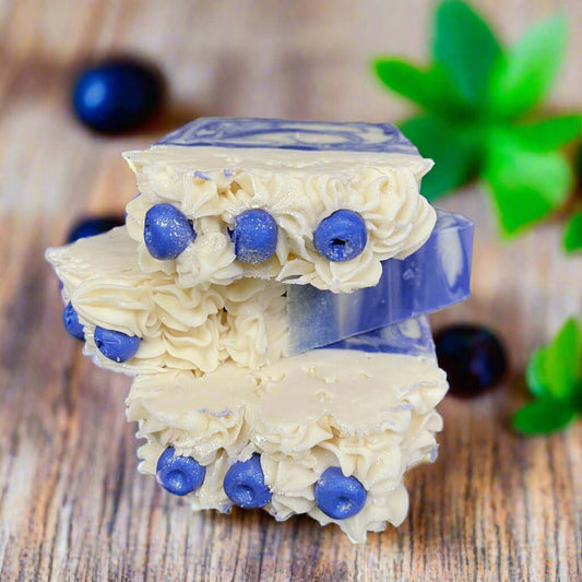 Huckleberry Harvest Soap bars with natural blueberry accents on a rustic wooden surface.