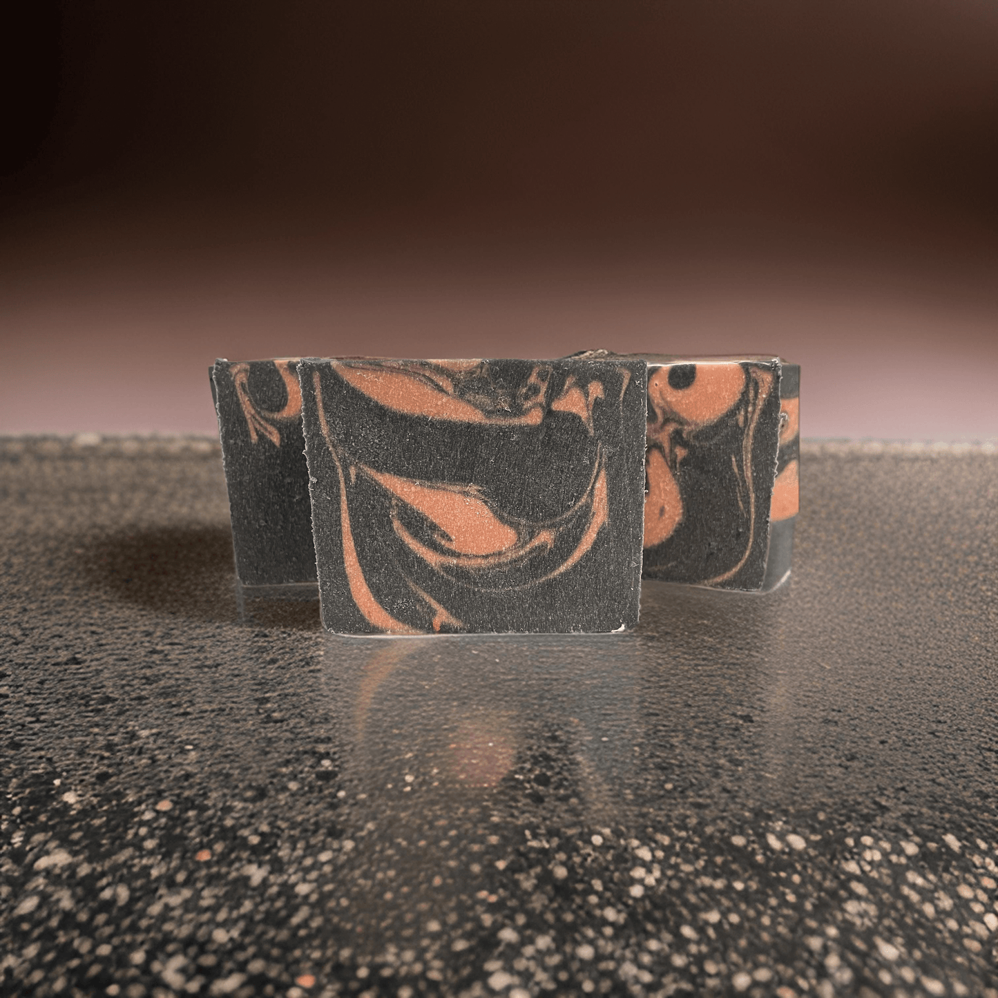 Natural vegan face soap bar with marbled pink and black design, perfect for cleansing and exfoliating.