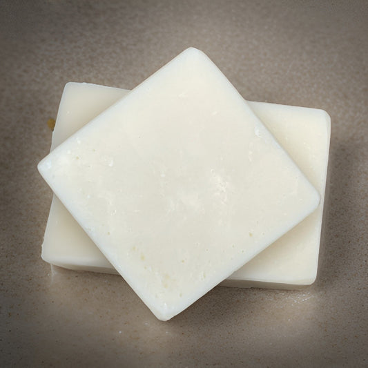 Two organic lemon soap bars stacked on a neutral surface, showcasing their smooth, gentle texture.