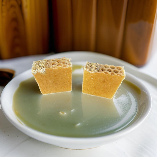 Handmade Natural Oatmeal Milk and Honey Soap bars on a dish, showcasing their creamy texture and honeycomb appearance.