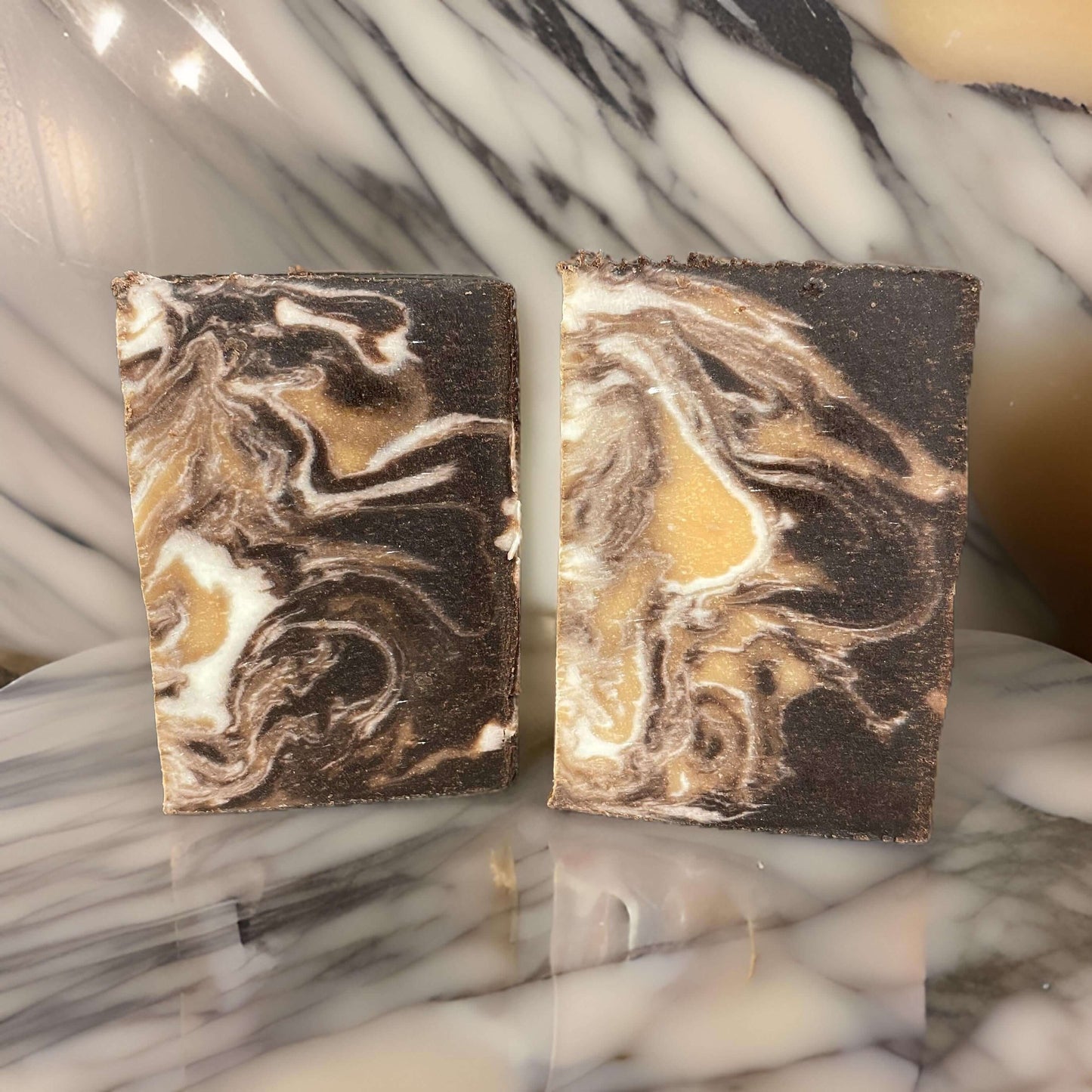 Vegan Bourbon N Butterscotch Soap bars displaying rich, swirled colors on a marble background.