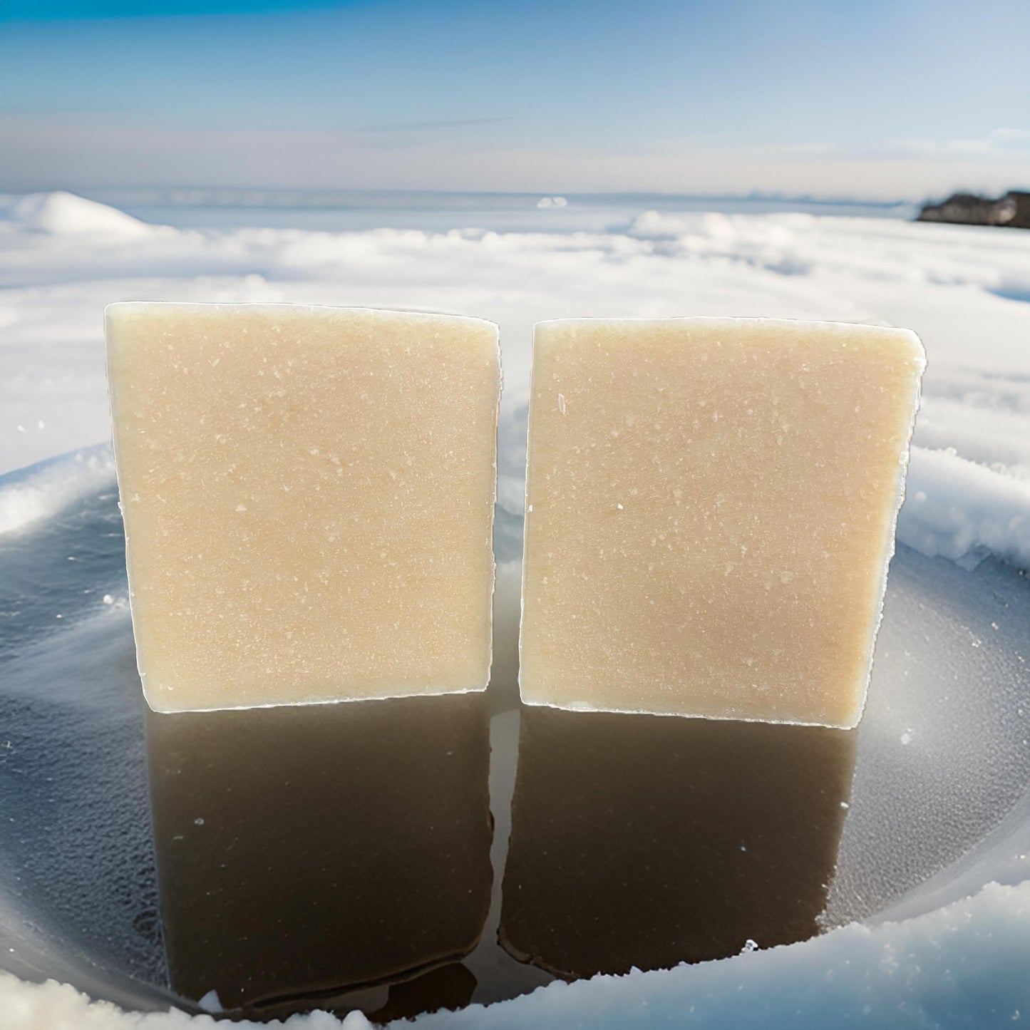 Two bars of Organic Beef Tallow Soap-Purely displayed on a reflective surface in a snowy outdoor setting.