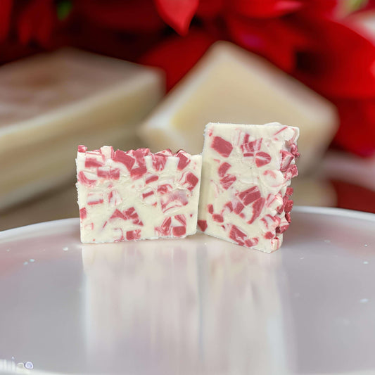 Two pieces of Vegan Peppermint Soap with red and white swirls on a glass plate, showcasing its nourishing and chemical-free quality.