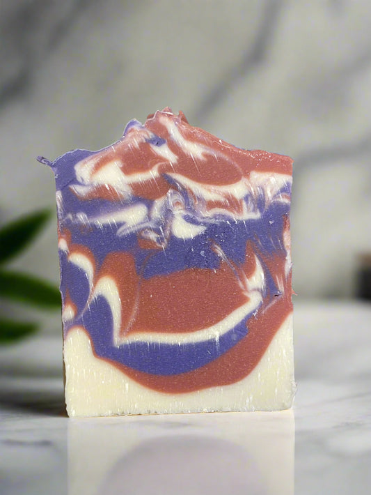 Handcrafted Black Raspberry Vanilla soap featuring vibrant swirls of purple and pink on a creamy white base.