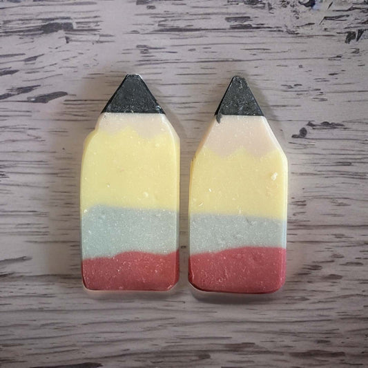 Vegan pencil-shaped soaps in yellow, pink, and blue colors, perfect for teacher appreciation gifts.
