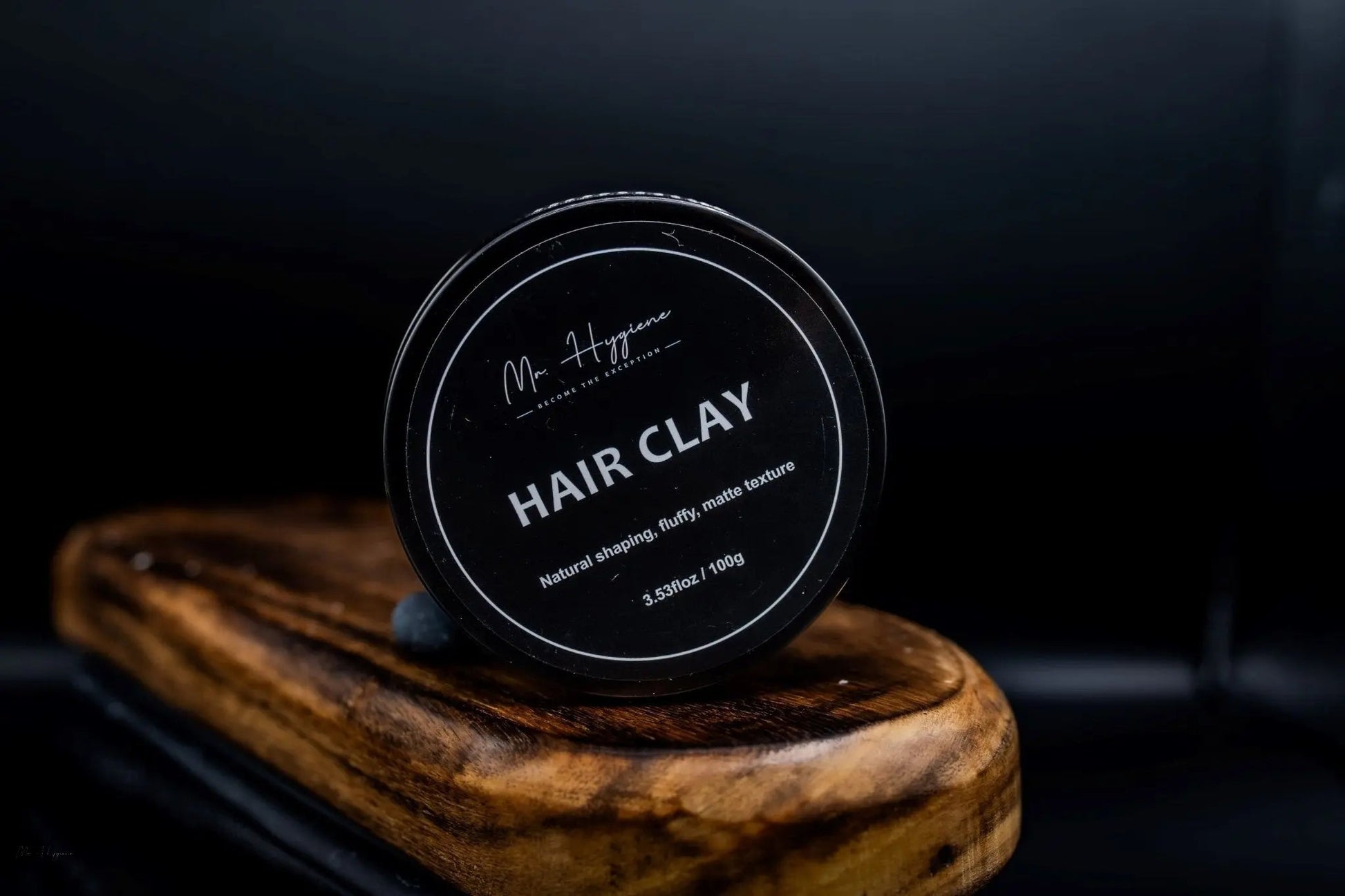 Matte Finish Hair Clay in a black jar with natural styling, sitting on a wooden surface.