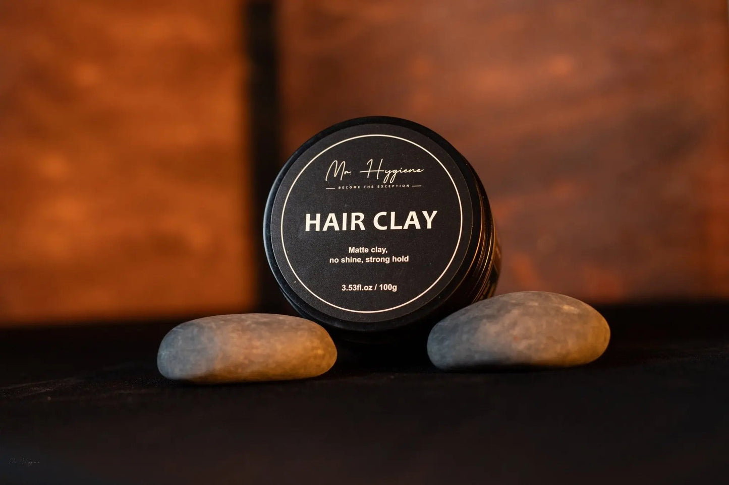 Matte Finish Hair Clay in a jar with smooth stones, highlighting its strong hold and natural look.