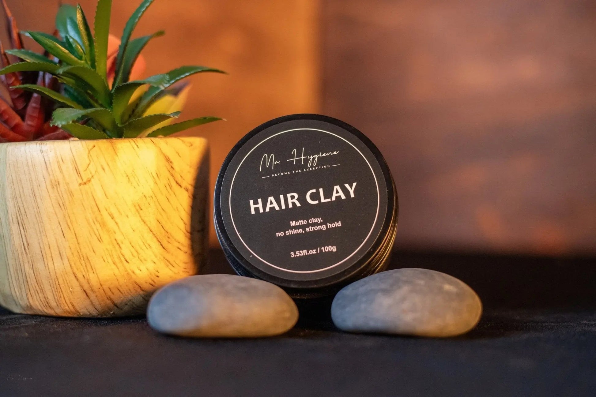 Matte Finish Hair Clay in a jar with stones and a plant, showcasing strong hold and natural look.