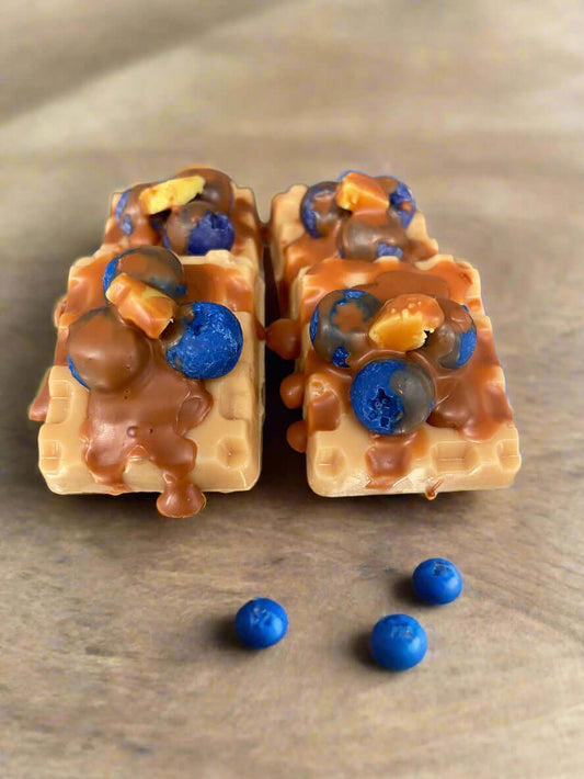 Blueberry waffles wax melts in a decorative shape with blueberry and syrup details, on a wooden surface.