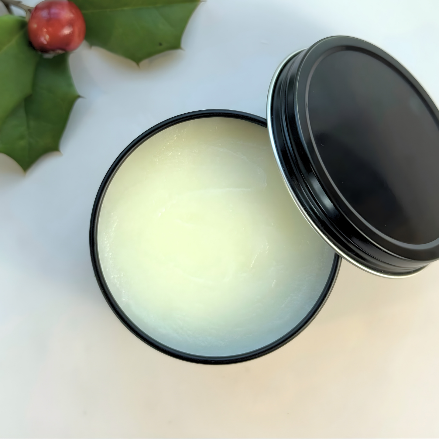 Strong salve in a black tin container, showcasing its smooth texture for dry, cracked skin relief.